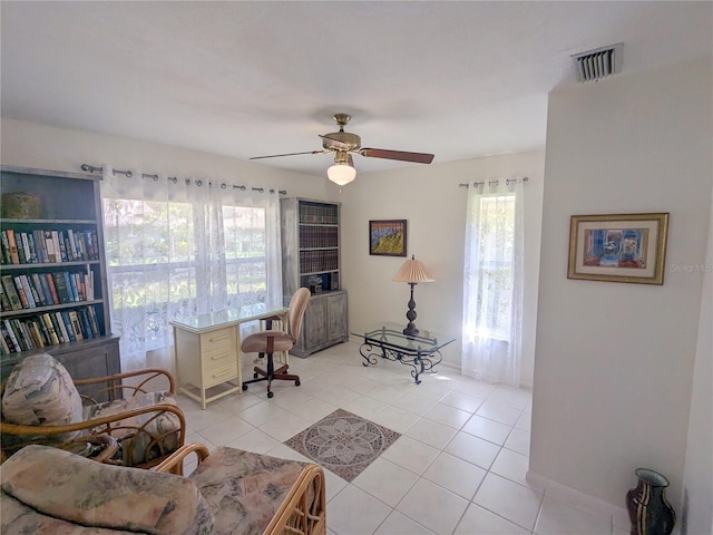 office area featuring ceiling fan, light tile patterned flooring, and a healthy amount of sunlight