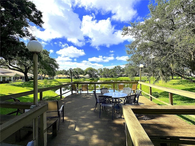 wooden terrace with a yard and a water view