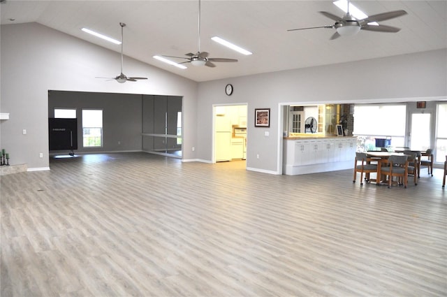 living room with light wood-type flooring, high vaulted ceiling, and ceiling fan