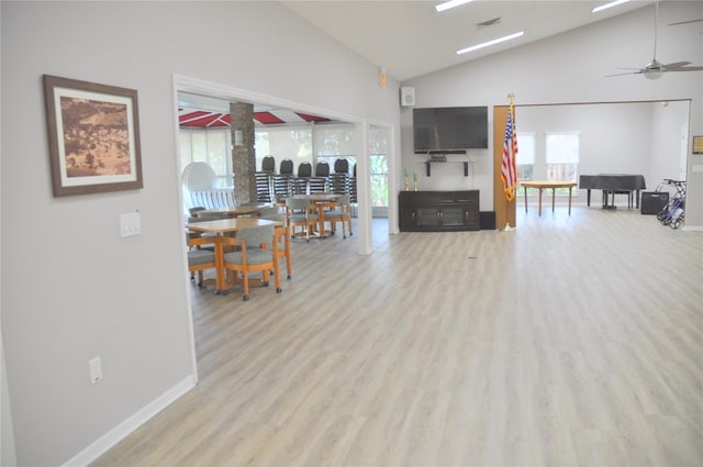 living room with high vaulted ceiling, ceiling fan, and light hardwood / wood-style flooring