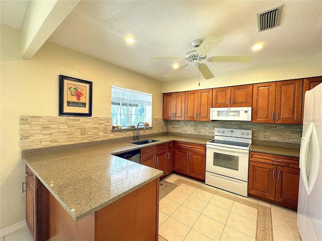 kitchen with tasteful backsplash, white appliances, light stone counters, sink, and kitchen peninsula