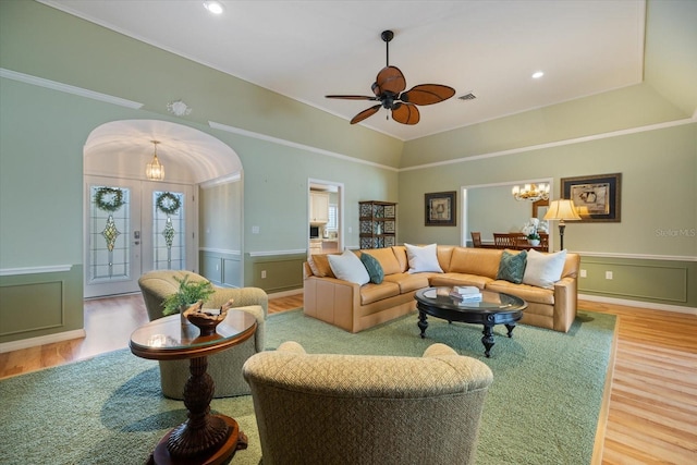 living room featuring ceiling fan with notable chandelier, hardwood / wood-style floors, and french doors