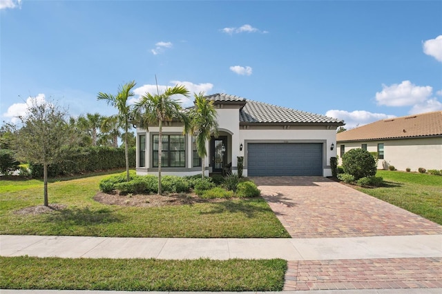 mediterranean / spanish house featuring a garage, a tile roof, decorative driveway, a front lawn, and stucco siding