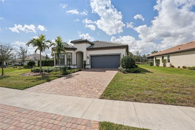 mediterranean / spanish-style house featuring a front yard and a garage