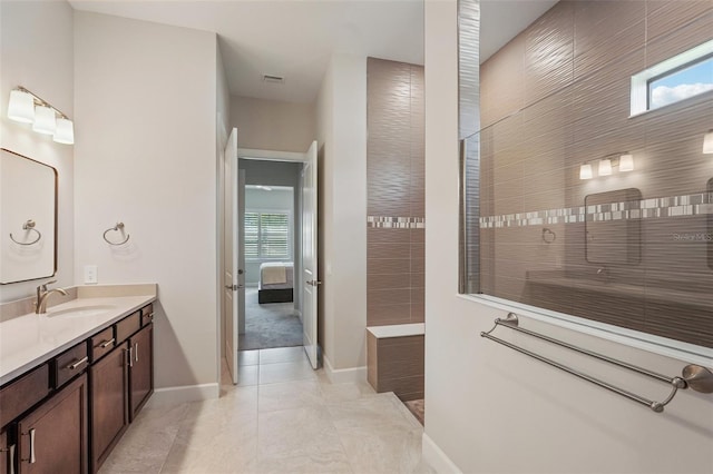 bathroom featuring tile patterned flooring, vanity, and walk in shower