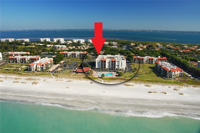 birds eye view of property featuring a water view and a beach view