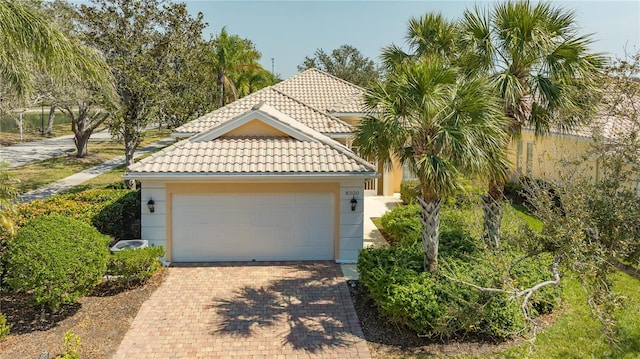 view of front facade with decorative driveway, a tiled roof, and stucco siding