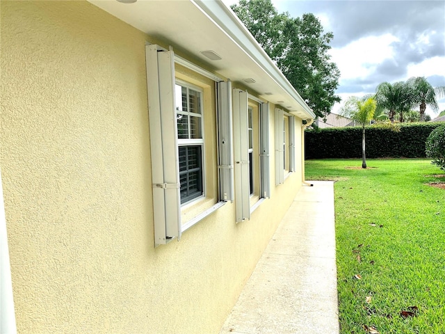 7649 Quinto Dr, Sarasota, FL 34238 - view of side of property featuring a yard and stucco siding
