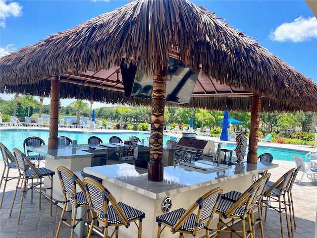 7649 Quinto Dr, Sarasota, FL 34238 - view of patio featuring a community pool, a grill, a gazebo, and outdoor wet bar