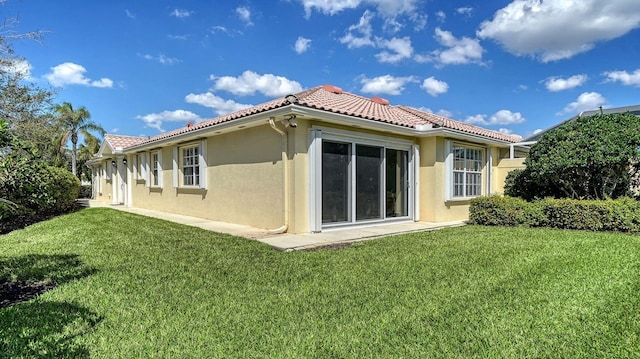 7649 Quinto Dr, Sarasota, FL 34238 - back of house featuring a lawn, stucco siding, and a tile roof