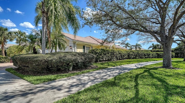7649 Quinto Dr, Sarasota, FL 34238 - view of side of property with a lawn, stucco siding, and a tiled roof