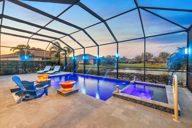 pool at dusk featuring a lanai, a patio area, pool water feature, and an in ground hot tub