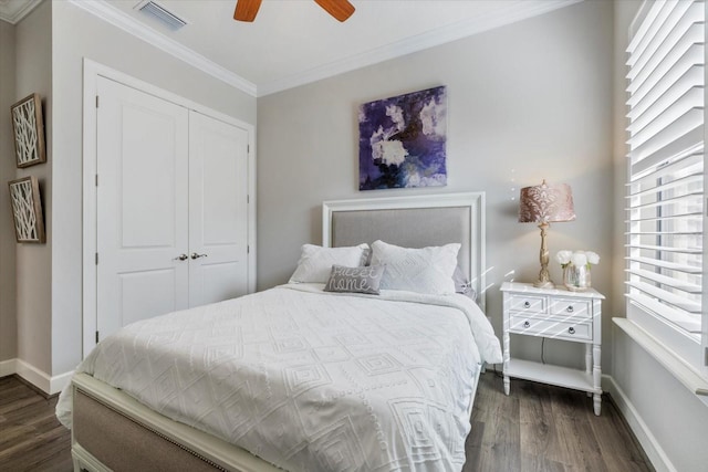 bedroom with crown molding, ceiling fan, dark hardwood / wood-style flooring, and a closet