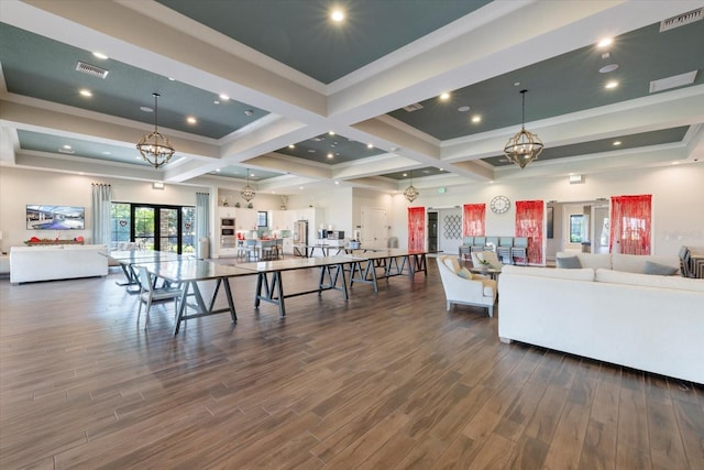 living room featuring dark wood-type flooring, coffered ceiling, an inviting chandelier, crown molding, and beam ceiling