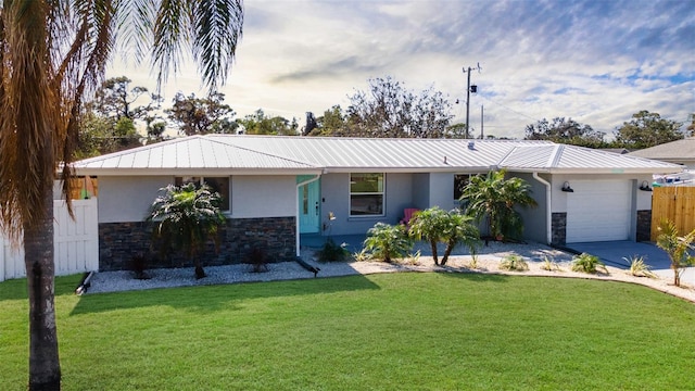 single story home featuring fence, an attached garage, stucco siding, a front lawn, and stone siding