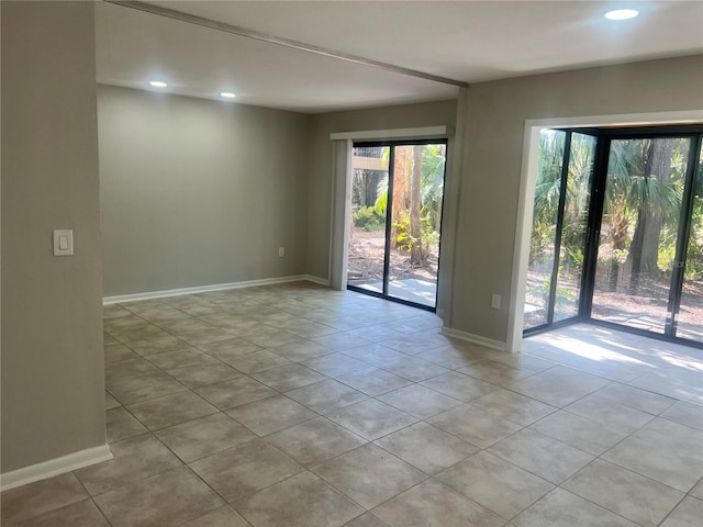 tiled spare room featuring baseboards and recessed lighting