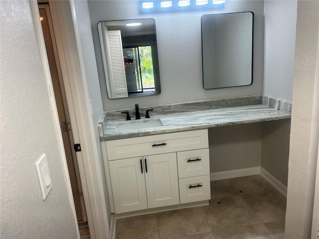 bathroom with tile patterned floors, baseboards, and vanity