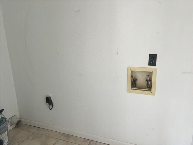 laundry room featuring baseboards, light tile patterned flooring, hookup for a washing machine, and laundry area