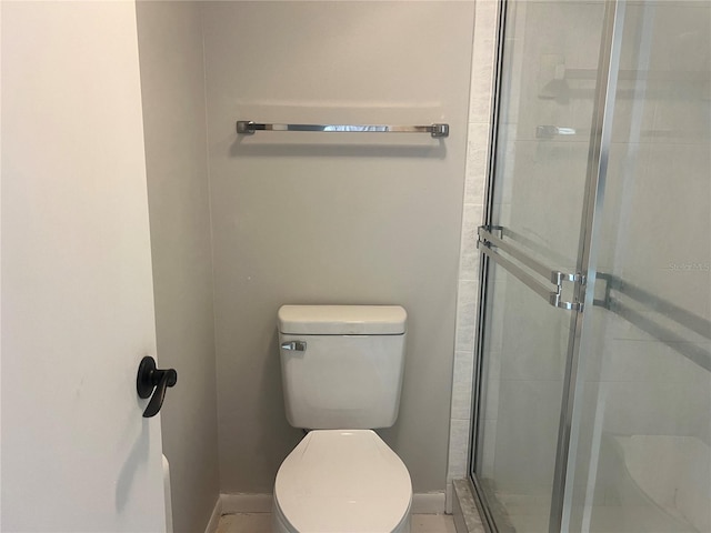 full bath featuring a shower stall, toilet, and baseboards