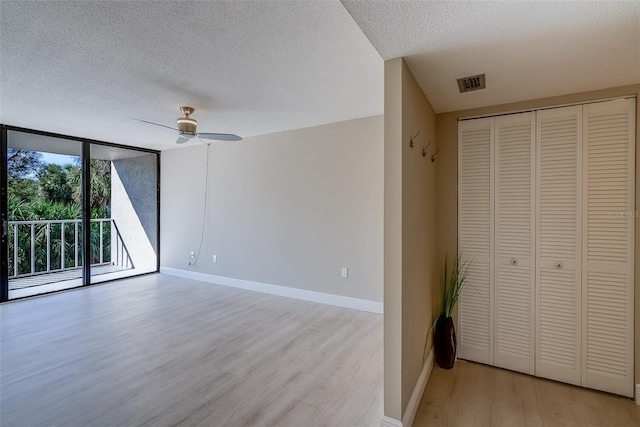 unfurnished bedroom with light wood-type flooring, expansive windows, access to exterior, and baseboards