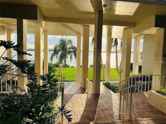 view of patio with covered porch and a water view