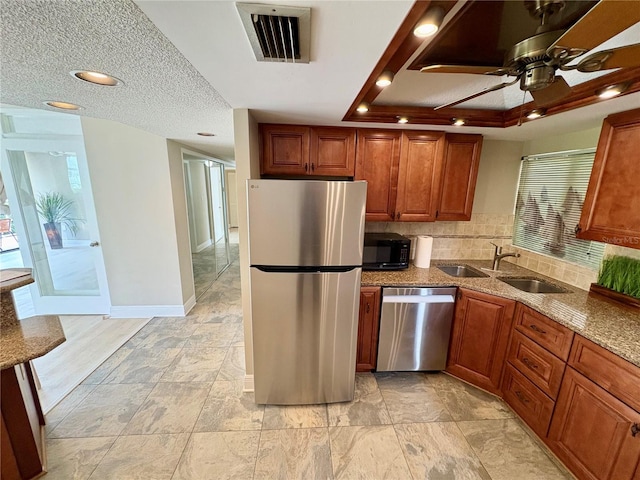 500 N Osceola Ave Unit 203, Clearwater, FL 33755 - kitchen featuring stainless steel appliances, a sink, decorative backsplash, stone counters, and brown cabinetry