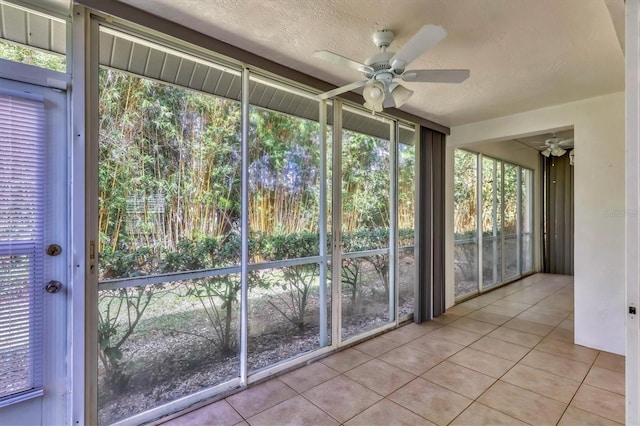 unfurnished sunroom featuring ceiling fan