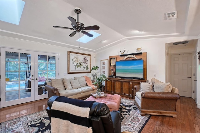 living room featuring lofted ceiling with skylight, french doors, visible vents, and wood finished floors