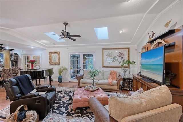 living area featuring a ceiling fan, french doors, crown molding, and wood finished floors