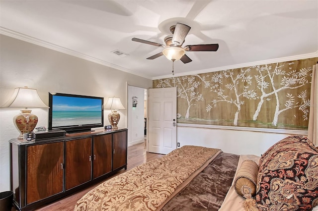 bedroom with light wood-style flooring, visible vents, ceiling fan, and ornamental molding