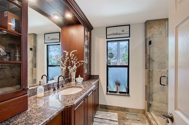 bathroom featuring a shower stall, baseboards, and vanity