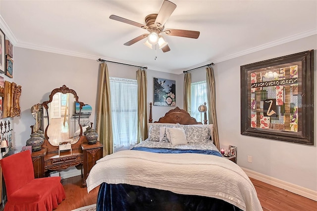 bedroom featuring ornamental molding, a ceiling fan, baseboards, and wood finished floors