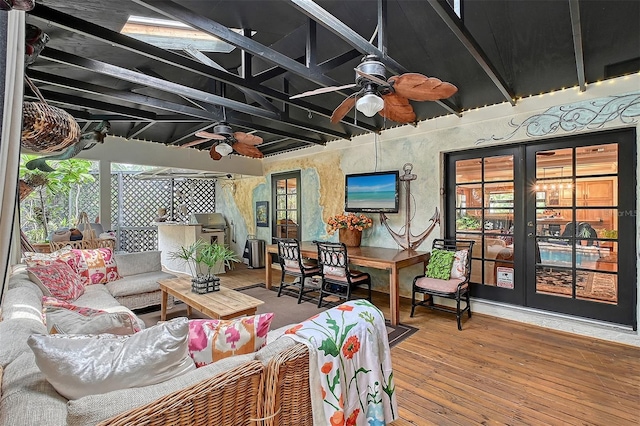 sunroom with ceiling fan and beamed ceiling