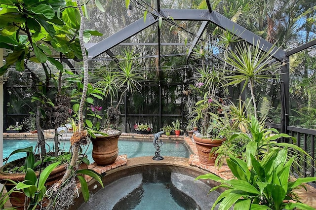 outdoor pool with an in ground hot tub and glass enclosure