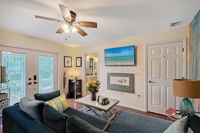 living room with french doors, visible vents, dark wood-type flooring, a ceiling fan, and beverage cooler