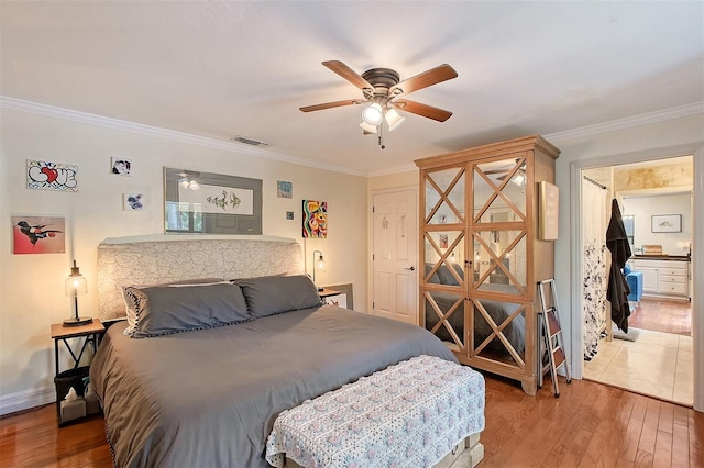 bedroom featuring crown molding, visible vents, a ceiling fan, wood finished floors, and baseboards