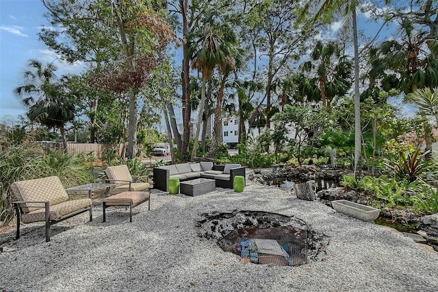 view of patio / terrace with fence and an outdoor living space with a fire pit