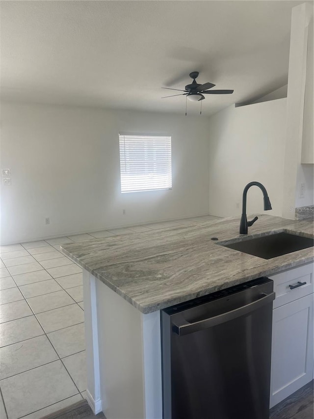 kitchen with dishwasher, light stone countertops, white cabinets, light tile patterned floors, and sink