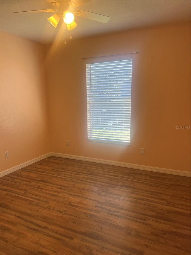 empty room featuring ceiling fan and dark hardwood / wood-style floors