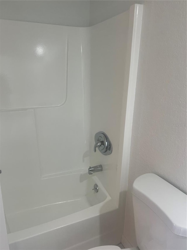 bathroom with bathtub / shower combination and toilet