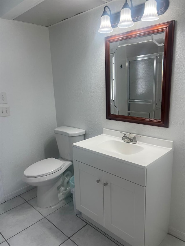 bathroom with toilet, tile patterned floors, an enclosed shower, and vanity