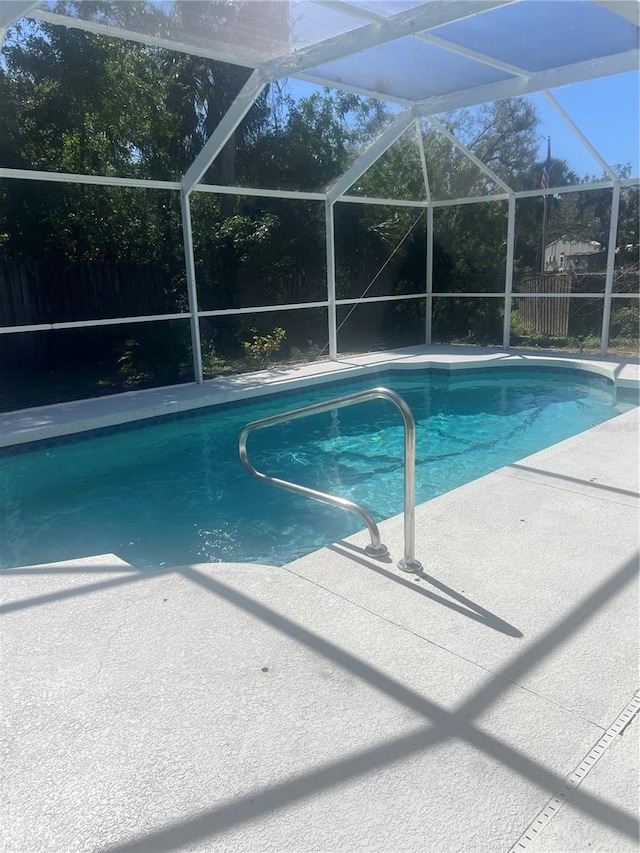 view of swimming pool with glass enclosure and a patio