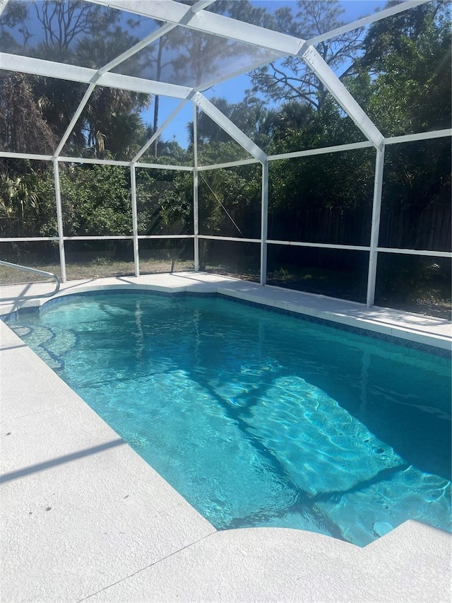 view of swimming pool featuring a lanai