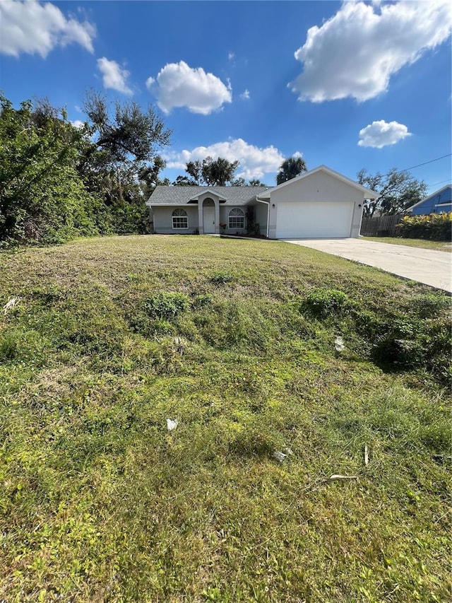 view of front facade featuring an attached garage, driveway, fence, and a front yard