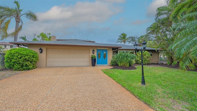 view of front of home featuring a front yard, concrete driveway, an attached garage, and stucco siding