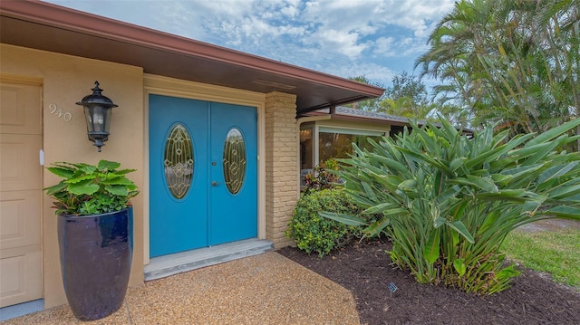 doorway to property featuring stucco siding