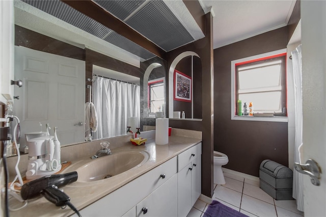 bathroom with tile patterned floors, vanity, toilet, and ornamental molding