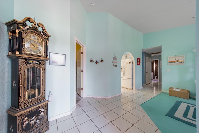 interior space with a towering ceiling and tile patterned floors