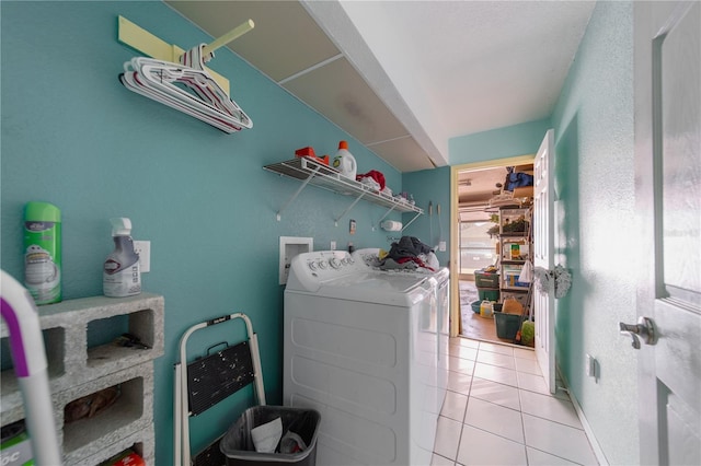 clothes washing area with separate washer and dryer and light tile patterned floors