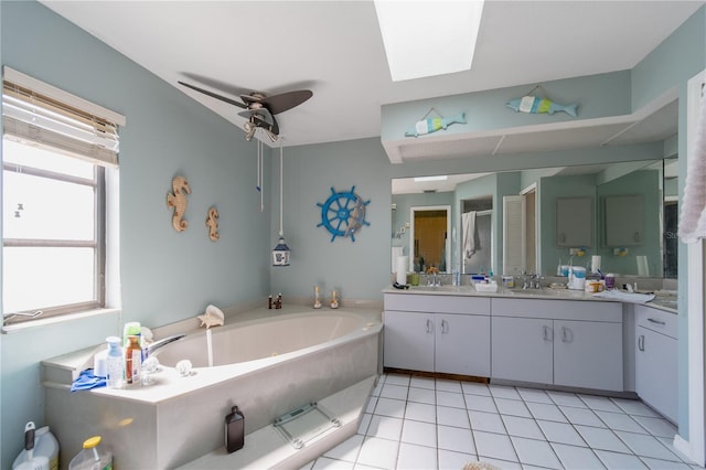 bathroom with ceiling fan, tile patterned flooring, a bathtub, a skylight, and vanity